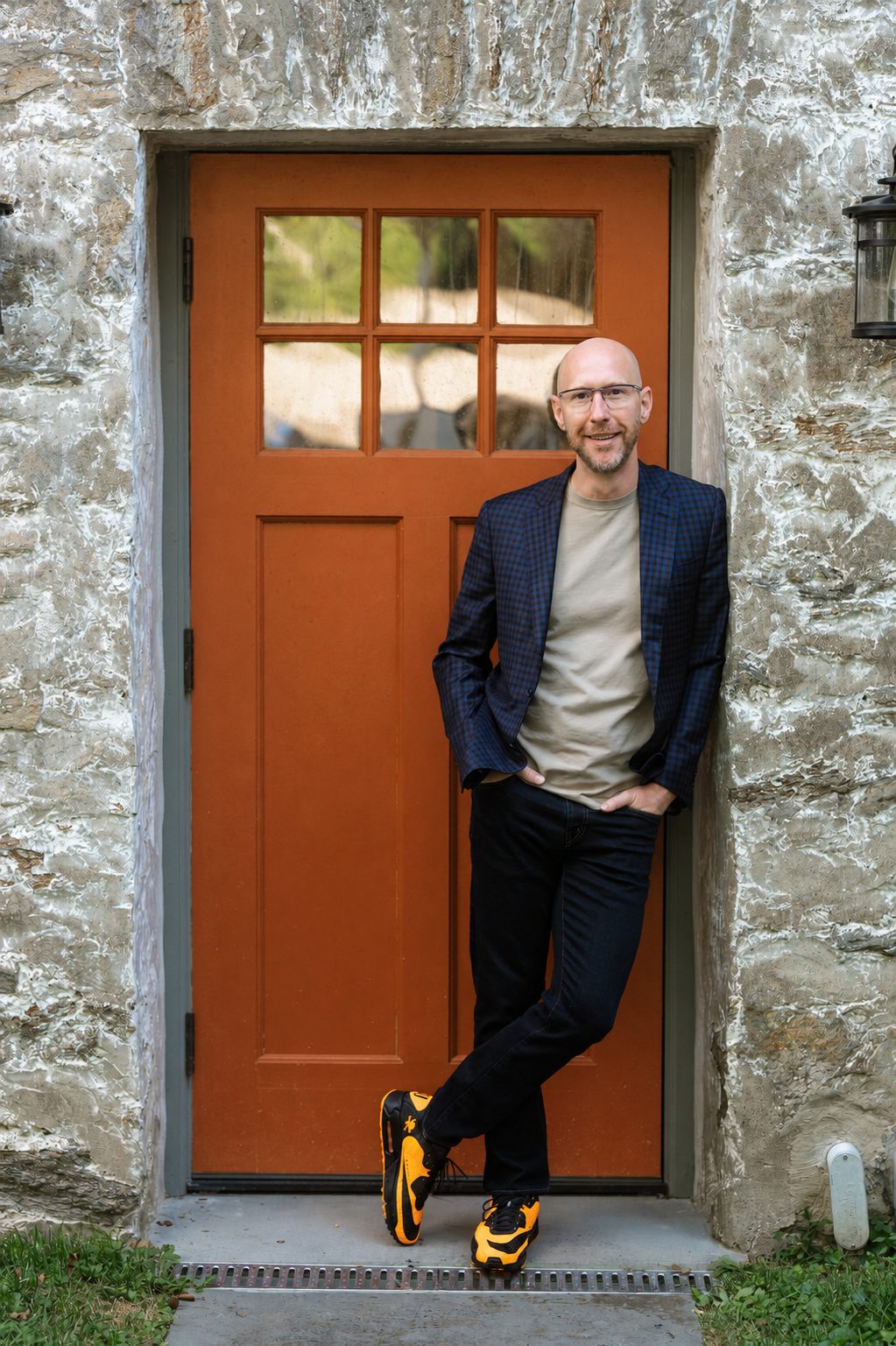 Dennis O'Donnell leaning against a stone doorway with an orange craftsman door